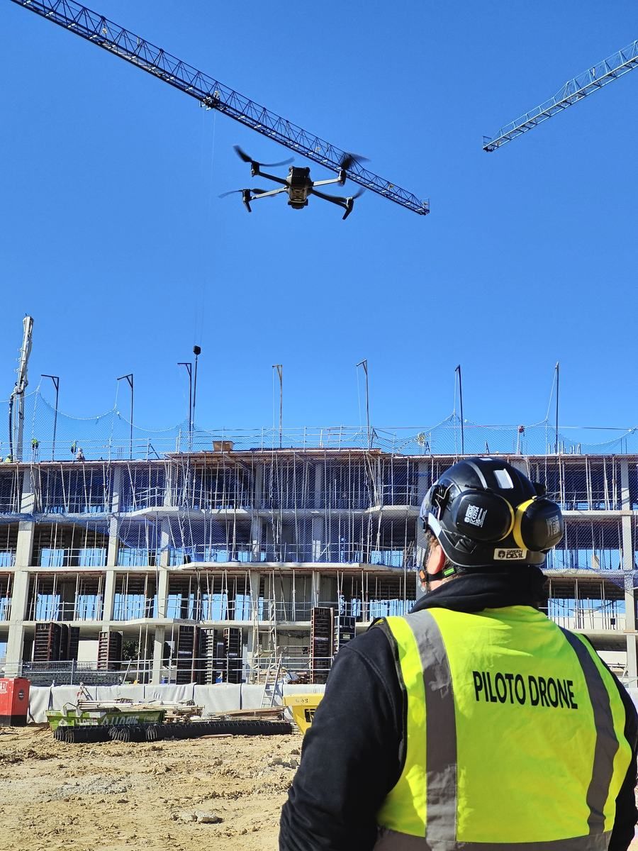 Drone pilot in a hi-vis vest working on a construction site